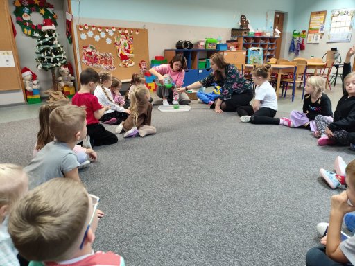 grupa Dinusi�w siedz�ca w kr�gupodczas zaj��